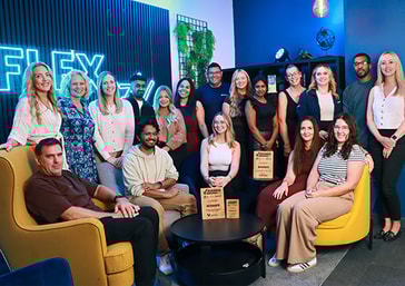 Fleximize team celebrating a supportive, people-first culture in our modern office, with trophies for the “Fintech Employer Award” and “Diversity & Inclusion Award ” for 2025 proudly on display.